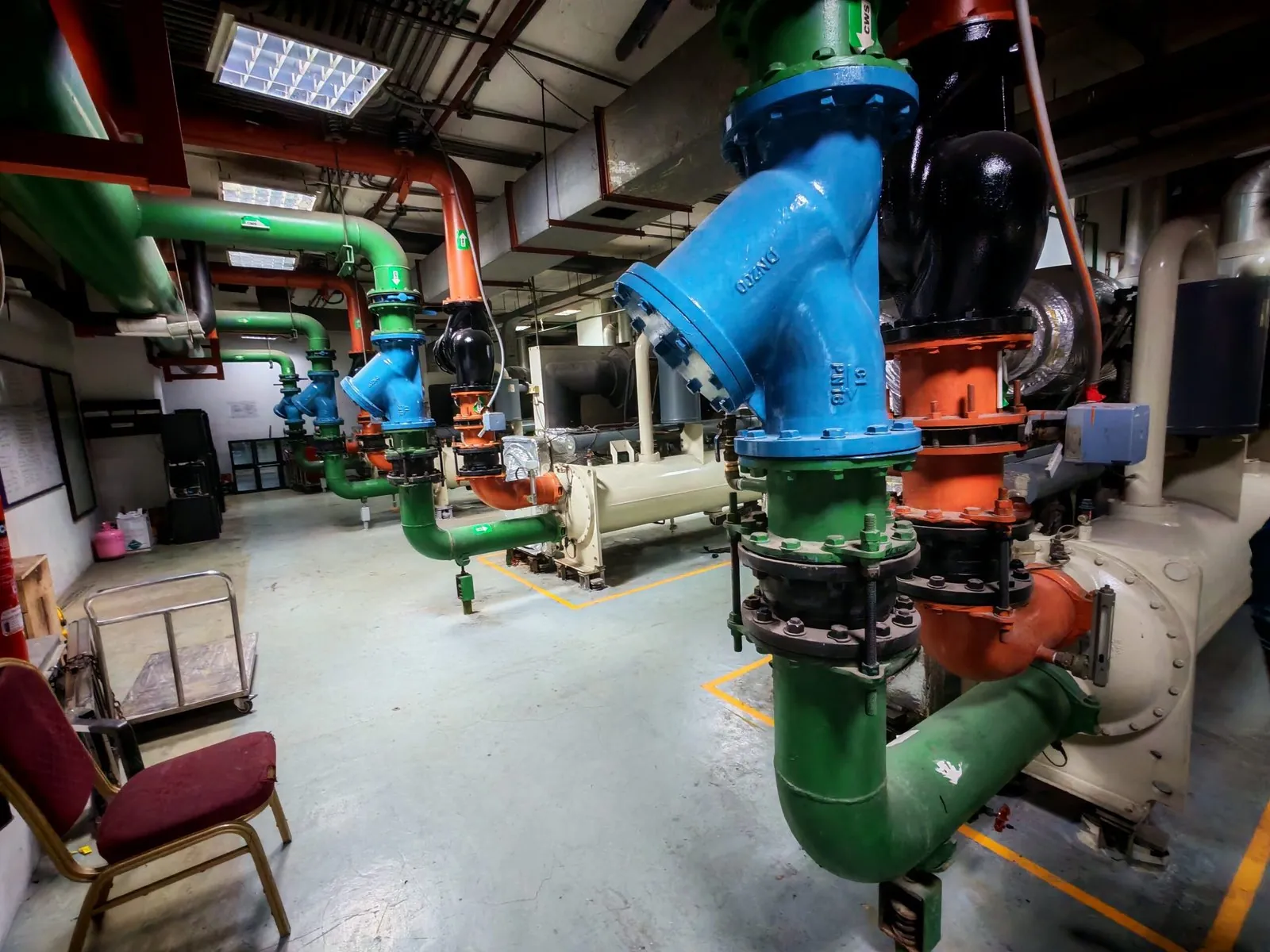 Chilled water pumps and colour-coded pipework in a plant room