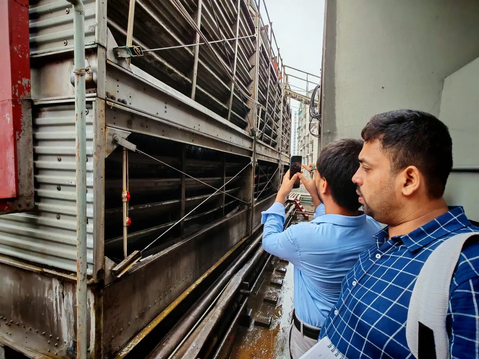 Engineers photographing a cooling tower during a survey