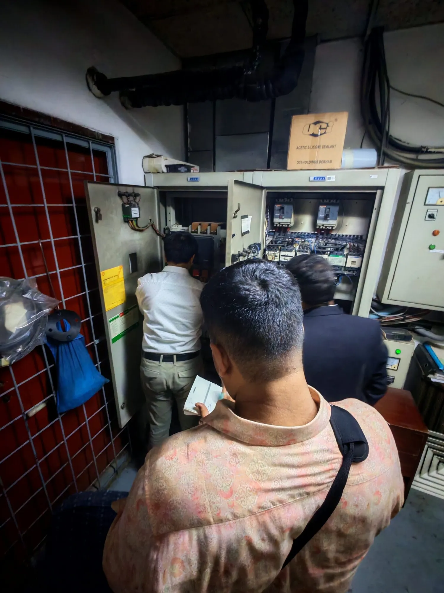 Engineers beside a power distribution panel