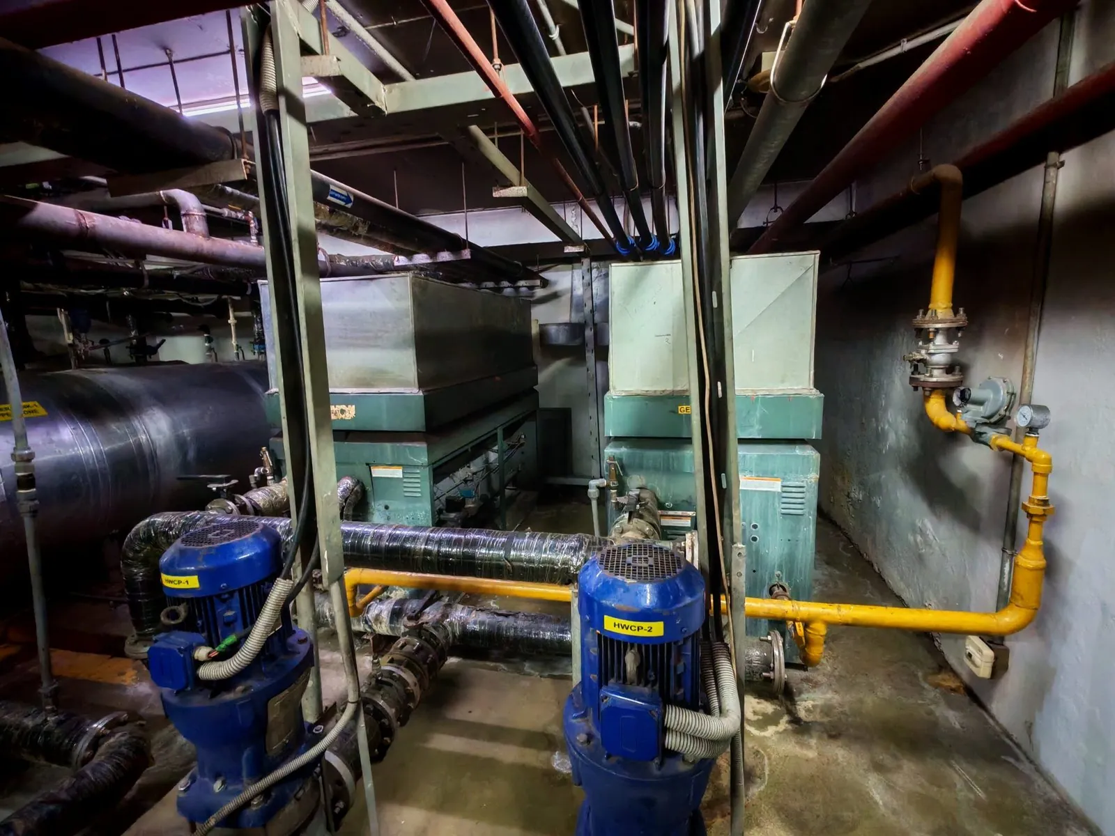 Pump room with blue pumps and a yellow gas line