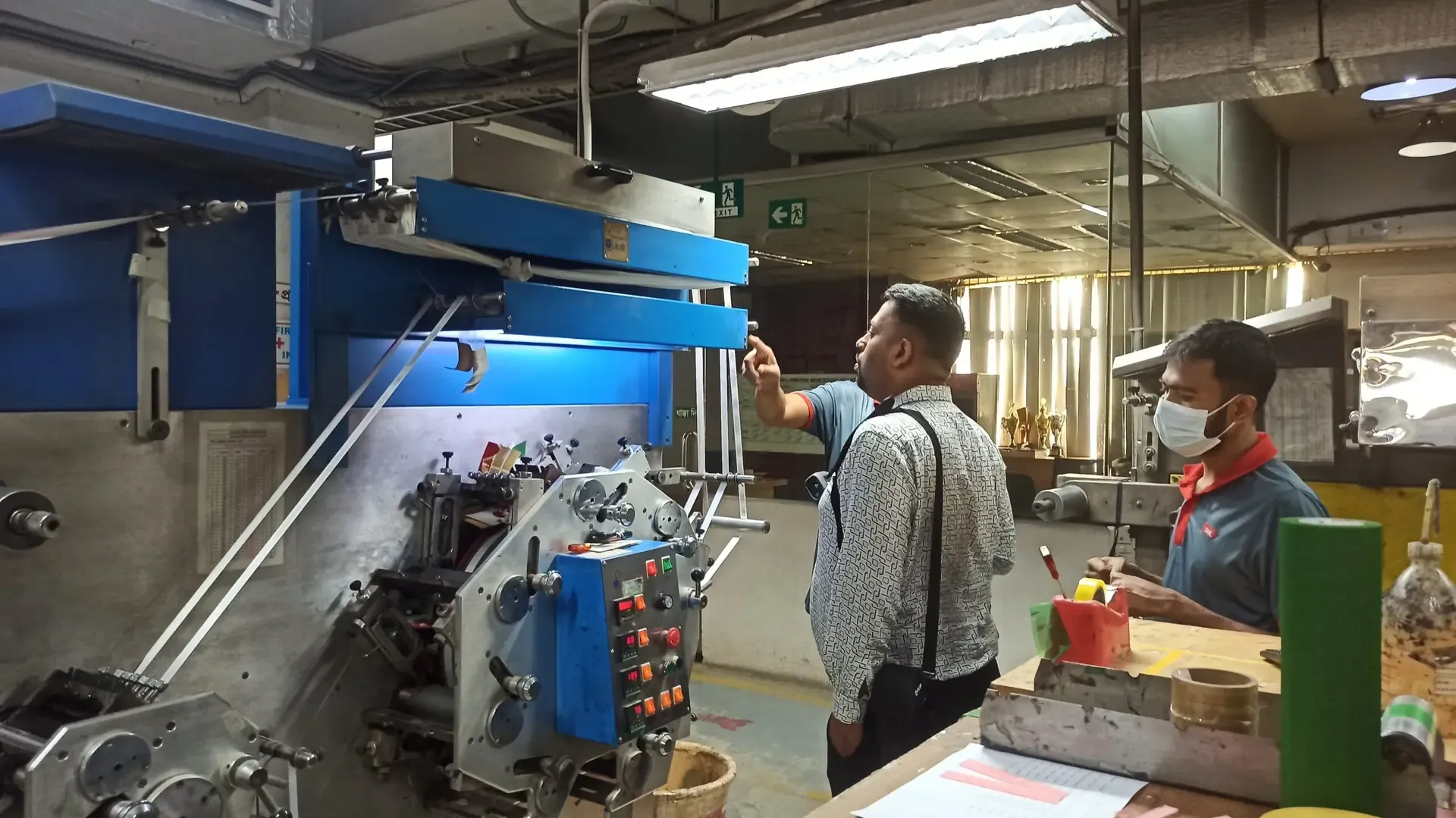 Engineers inspecting a machine in a production hall
